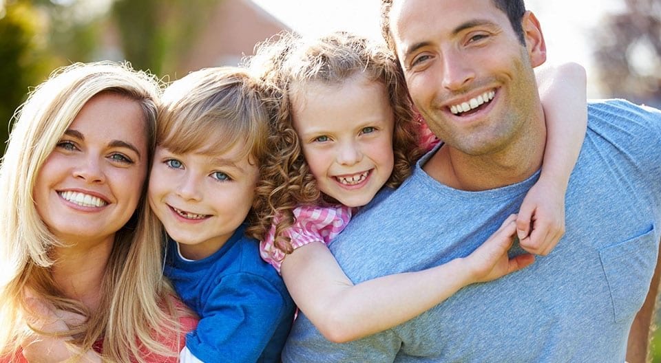 A man and two girls are hugging each other.